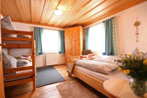 a bedroom with two bunk beds and a table at Almliesl BHOF-676 in Bischofshofen