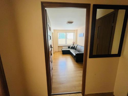 - un couloir avec un miroir et un canapé dans l'établissement Apartament Bryza, Willa Perla 100m od morza, à Gdańsk