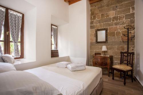 ein Schlafzimmer mit zwei Betten und einem Tisch und einem Stuhl in der Unterkunft The Knight's House Old Town Rhodes in Rhodos (Stadt)