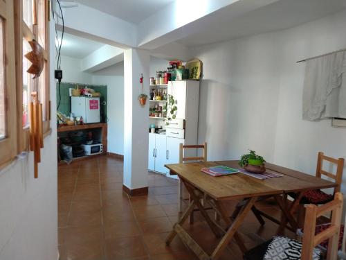 a kitchen with a wooden table and a refrigerator at EL HOSTELITO in Iruya