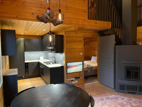 a kitchen with a table and a room with a bed at Villa Kyyhkynen in Rovaniemi