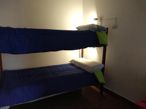 2 łóżka piętrowe w pokoju z mniejszym łóżkiem w obiekcie EL HOSTELITO w mieście Iruya