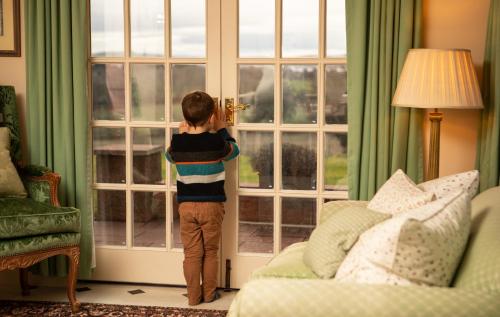 a young child opening the door to a living room at Balnagown Estates in Kildary
