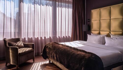 una camera d'albergo con letto e sedia di Roomers, Frankfurt, a Member of Design Hotels a Francoforte sul Meno