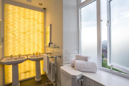 a bathroom with two sinks and a yellow shower curtain at Eagle and Child, Ramsbottom in Bury