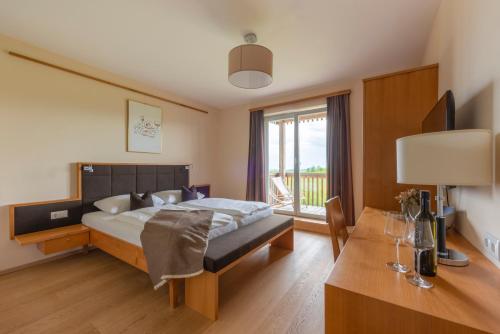 a bedroom with a bed and a desk and a window at Weingut Dreisiebner Stammhaus in Gamlitz