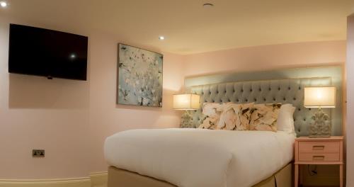 a bedroom with a large bed and a flat screen tv at The Hotel Chester in Chester