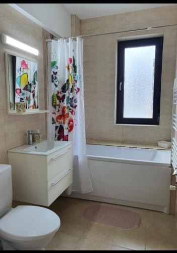 un bagno con vasca, WC e finestra di Studio Camy a Mamaia Nord - Năvodari