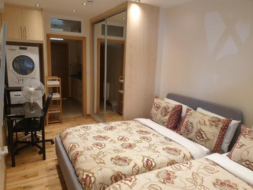 a living room with a bed and a kitchen at London Luxury Apartments 1min walk from Underground, with FREE PARKING FREE WIFI in London