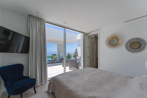 a bedroom with a bed and a chair and a window at Villa Abama in Tejina de Isora