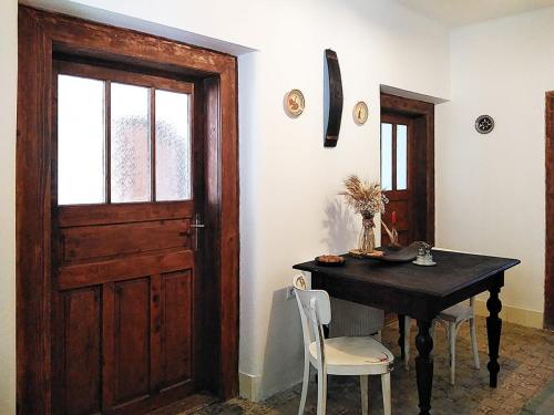 a dining room with a table and a wooden door at Family Apartman Szádelő - Zádiel in Zádiel