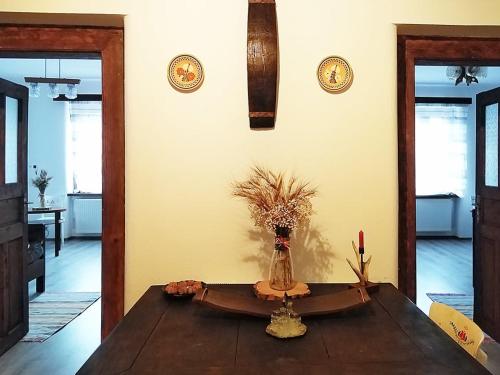a room with a table with a vase of flowers on it at Family Apartman Szádelő - Zádiel in Zádiel