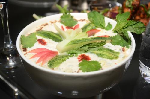 a bowl of soup with vegetables in it on a table at The Golden Sunrise Hotel in Nainital