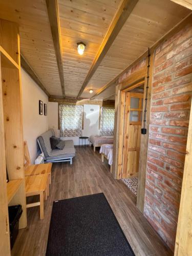 a living room in a tiny house with a brick wall at MOTOMYCZKI-motel in Myczkowce