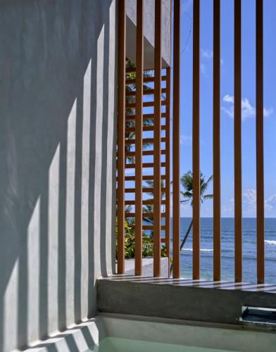 a view of the beach from a balcony with a fence at Harding Boutique Hotel in Ahangama