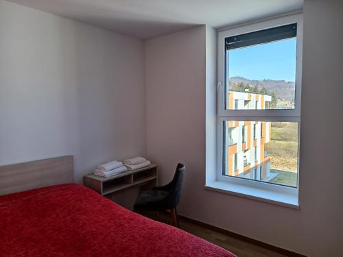 um quarto com uma cama vermelha e uma janela em DALGONA apartma Godler, Podčetrtek em Podčetrtek