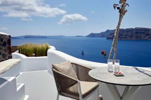 a patio with a table with a view of the ocean at Marizan Caves & Villas in Oia