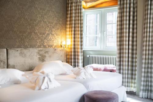 two beds in a room with a window at Hotel Suisse in Strasbourg