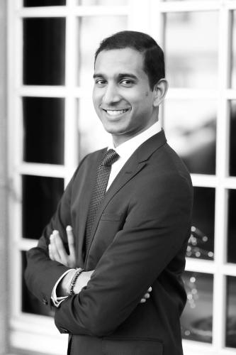 a man in a suit standing with his arms crossed at Hotel Suisse in Strasbourg
