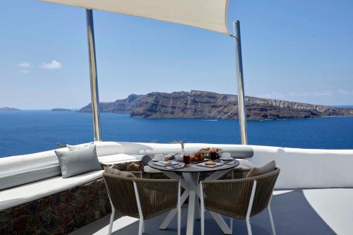 a table on a balcony with a view of the ocean at Marizan Caves & Villas in Oia