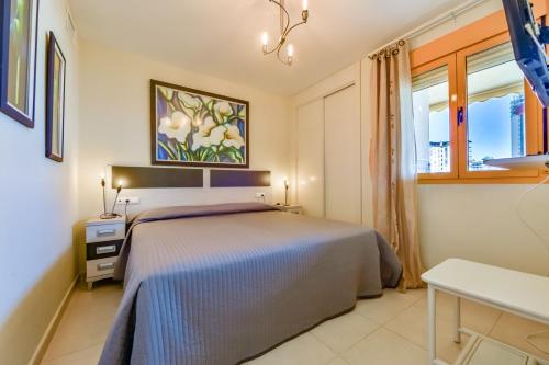1 dormitorio con 1 cama y una pintura en la pared en Apartamentos Ambar Beach (1-8º-B), en Calpe