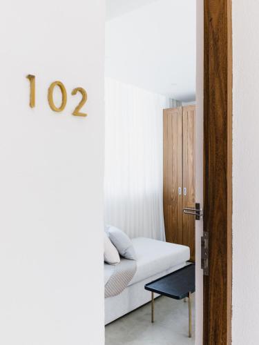 a bedroom with a bed and a clock on the wall at Harding Boutique Hotel in Ahangama