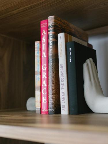 a row of books sitting on a shelf at Harding Boutique Hotel in Ahangama