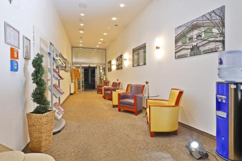 a waiting room with yellow and orange chairs at City Partner Central-Hotel Wuppertal in Wuppertal