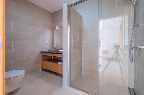 a bathroom with a shower with a toilet and a sink at Vila do Golfe Villa in Casal da Lagoa Seca