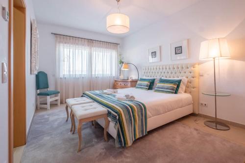 a bedroom with a bed and a table and a chair at Vila do Golfe Villa in Casal da Lagoa Seca