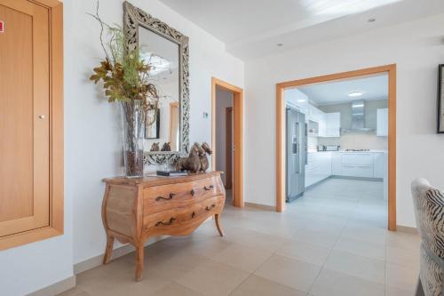 a living room with a wooden dresser and a mirror at Vila do Golfe Villa in Casal da Lagoa Seca