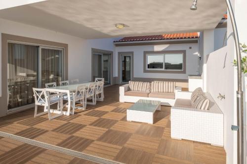 a living room with a table and a couch at Vila do Golfe Villa in Casal da Lagoa Seca