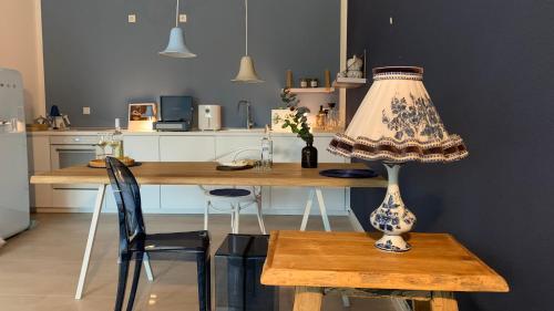Freya Blue Ferienhaus في Weener: طاولة مع مصباح جالس على طاولة في مطبخ