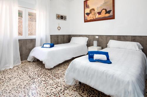 twee bedden in een kamer met witte lakens bij Casa Luna in Jávea
