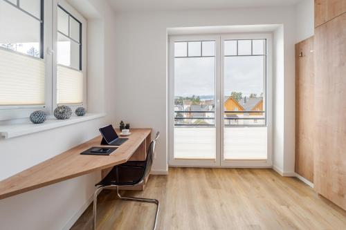 a home office with a desk and windows at Lipno - Lakeside Village - Větrník in Frymburk