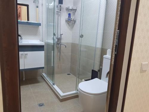 a bathroom with a shower and a toilet and a sink at Hotel Sharq in Dushanbe