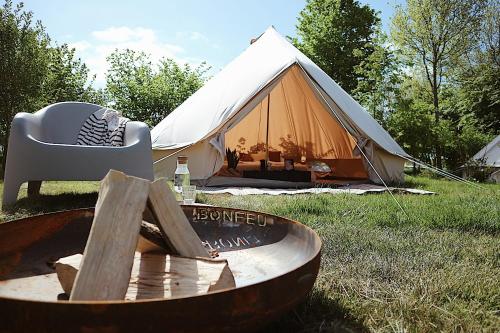 une tente avec une table et un tonneau devant. dans l'établissement Bell Tent Parc Bûten Jubbega, à Jubbega-Schurega