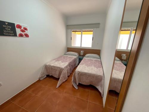 El Matorral的住宿－Airport Vv - Amolan，小房间设有两张床和镜子
