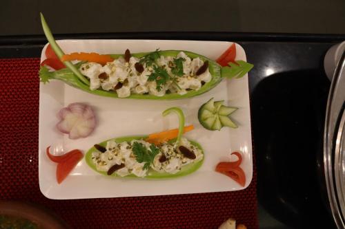 two peppers on a plate with vegetables on it at Royal Destiny Resort in Malaiyāndipattanam