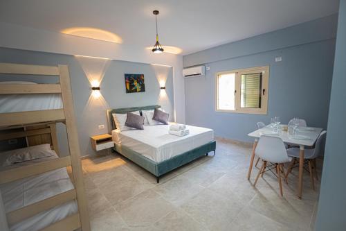 a bedroom with a bed and a table and a desk at Villa The Old Bakery in Qeparo