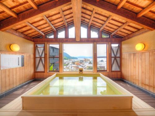 a large room with a large window and a pool at LiVEMAX RESORT Aki Miyajima in Miyajima