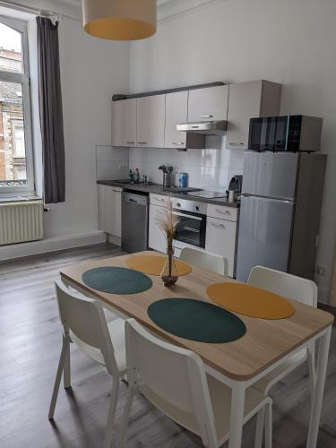 a kitchen with a wooden table and chairs in a room at Appart'Huy in Huy