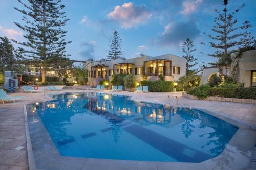 a swimming pool in front of a house at Your Memories Hotel in Gouves