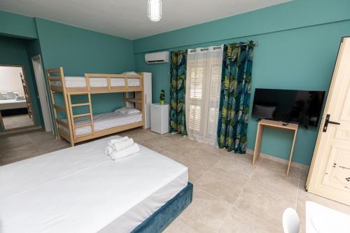 a bedroom with a bed and bunk beds in it at Villa The Old Bakery in Qeparo