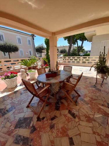 a patio with a wooden table and chairs at BOUGANVILLE casa vacanza ambiente climatizzato con wi fi in Pineto
