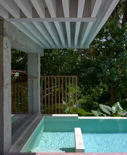 a swimming pool with a pergola next to a garden at Harding Boutique Hotel in Ahangama