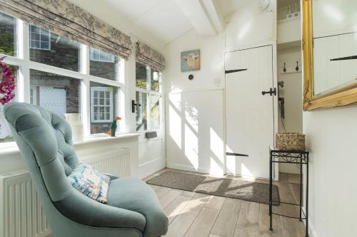 a living room with a blue chair and a window at The Old Dairy in Ambleside