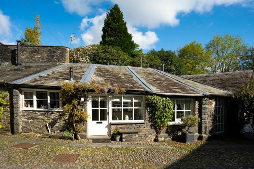 an old stone cottage with a white door at The Old Dairy in Ambleside
