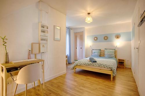 a bedroom with a bed and a desk in it at Le Grand Appart' proche commerces in Flers