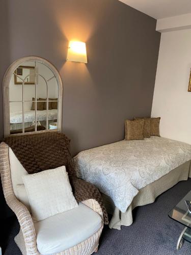 a room with a bed and a chair and a mirror at Hotel Restaurant du Parc en Bord de Rivière in Fontaine-de-Vaucluse